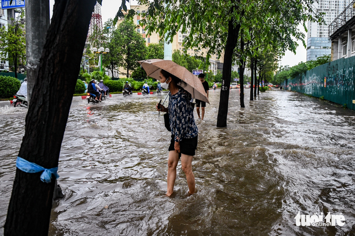Nước ngập lên vỉa hè đường Lê Văn Lương (Hà Nội) trong cơn mưa lớn - Ảnh: NAM TRẦN