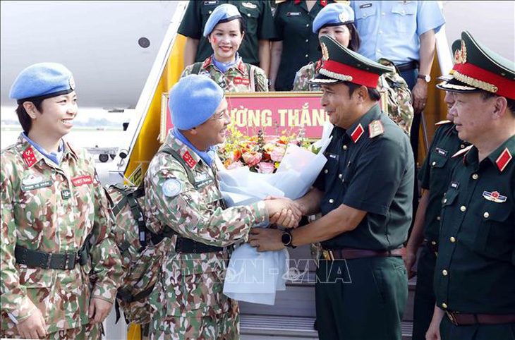 Thượng tướng Phùng Sĩ Tấn tặng hoa động viên cán bộ, nhân viên lên đường nhận nhiệm vụ - Ảnh: TTXVN