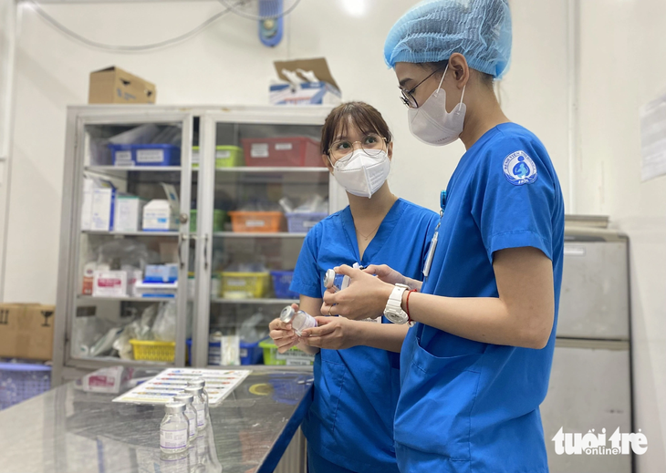 Nhân viên y tế Bệnh viện Nhi đồng 1 (TP.HCM) kiểm tra các lọ thuốc điều trị bệnh tay chân miệng - Ảnh: XUÂN MAI