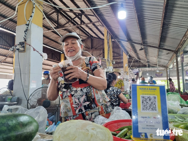 Tiểu thương bán rau ở chợ quê Đà Nẵng đều có mã QR để bà nội trợ thanh toán online - Ảnh: TRƯỜNG TRUNG