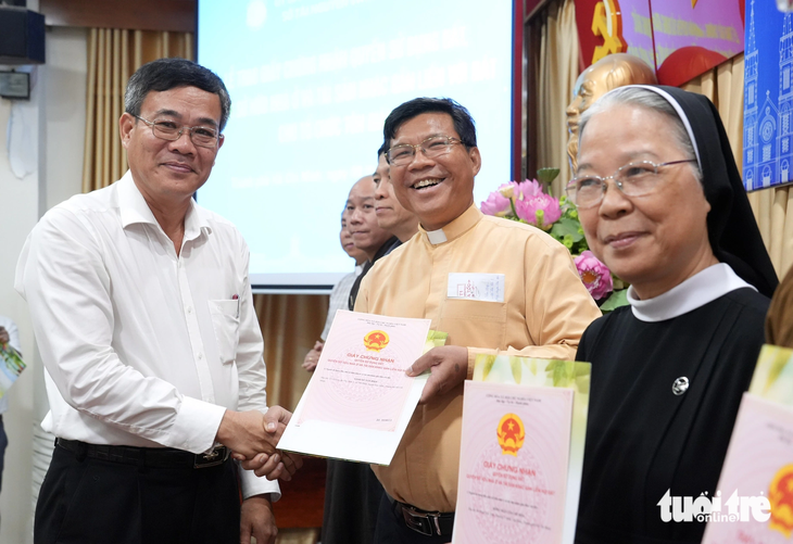 Ông Nguyễn Duy Tân, phó giám đốc Sở Nội vụ kiêm trưởng Ban Tôn giáo TP.HCM, trao &quot;sổ hồng&quot; cho các cơ sở tôn giáo - Ảnh: HỮU HẠNH
