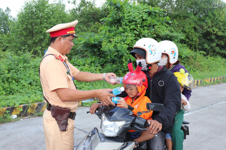 Người dân về quê nghỉ lễ được cảnh sát giao thông Sóc Trăng trao nước uống dọc đường - KHẮC TÂM