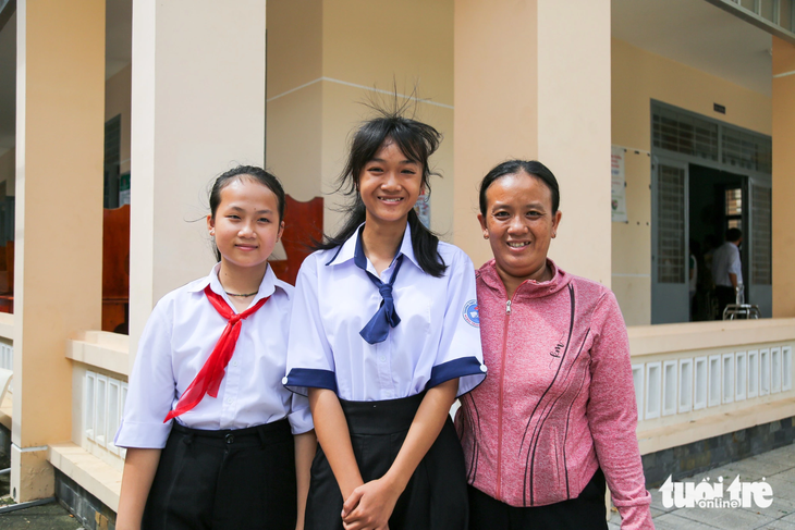 Niềm vui của ba mẹ con Mộng Kiều (giữa) khi nhận được học bổng để san sẻ học phí cho hai chị em vào đầu năm học mới - Ảnh: PHƯƠNG QUYÊN