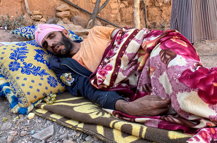 Ông Abdellatif Ait Bella bị thương trong trận động đất ngày 9-9 ở Morocco, phải ngủ dưới đất bên ngoài trời - Ảnh: REUTERS