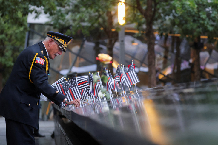 Ông Sam Pulia, cảnh sát về hưu, cắm cờ tại Đài tưởng niệm và Bảo tàng Quốc gia 11-9 để tưởng nhớ người anh họ là Thomas Casoria, cảnh sát của Sở Cảnh sát New York, mất ngày 11-9-2001 - Ảnh: REUTERS