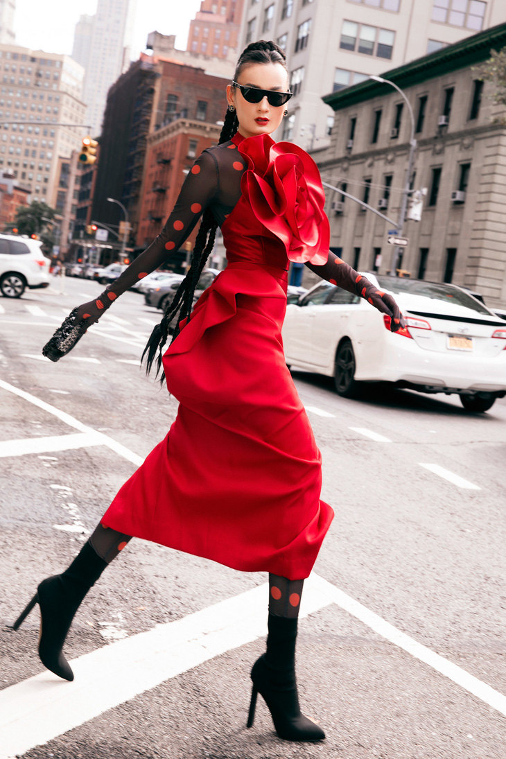 Người mẫu Lê Thúy diện bodysuit, phối cùng váy hoa 3D bên ngoài. Cô mang giày boots, phối cùng túi Chanel đen đồng điệu.