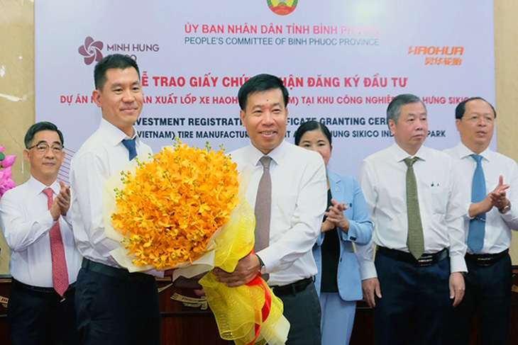 Bí thư Tỉnh ủy Bình Phước Nguyễn Mạnh Cường (phải) tặng hoa chúc mừng cho đại diện nhà đầu tư - Ảnh: AN BÌNH