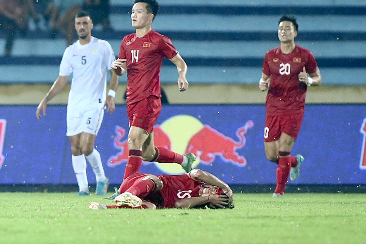 Triệu Việt Hưng nằm sân sau khi va chạm trên không với cầu thủ Palestine - Ảnh: HOÀNG TÙNG