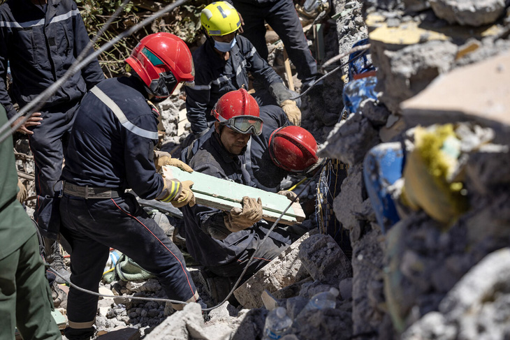 Lực lượng cứu hộ tìm kiếm trong đống đổ nát sau động đất ở Morocco - Ảnh: AFP