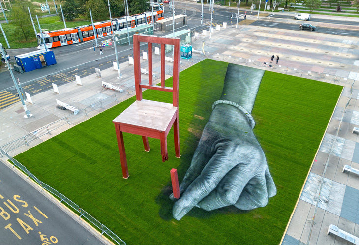 これは、紛争が今も続く地域の人々の運命を忘れないよう人々に思い出させるために、地面に手をついた絵を描いたアーティスト SAYPE の絵の名前です。 足の折れた椅子は芸術家ダニエル・ベルセットの作品で、戦後残された地雷によって障害を負った犠牲者を追悼するために、1997年にスイスのジュネーブにある国連ビルの前に建てられた - 写真: REUTERS