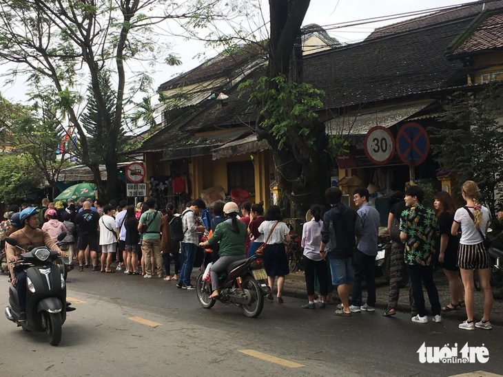 Du khách xếp hàng trên đường Phan Châu Trinh để được thưởng thức bánh mì Phượng - Ảnh: TRƯỜNG TRUNG
