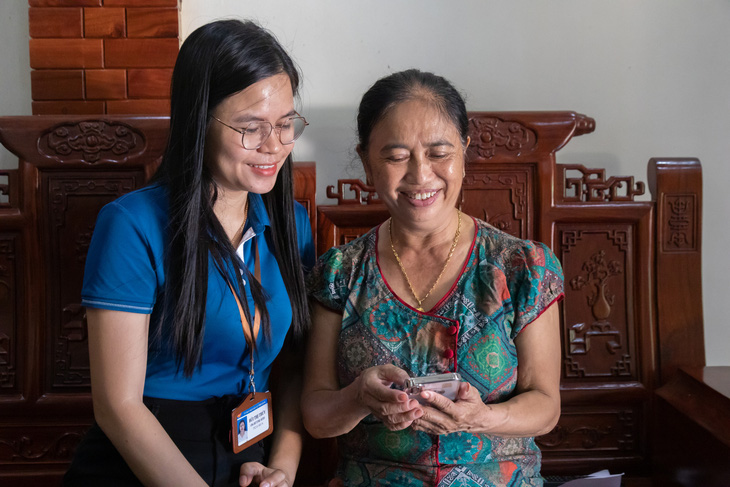 Bà Trần Thị Lạnh (phải) thao tác gửi hồ sơ hành chính tại nhà - Ảnh: Hoàng Táo
