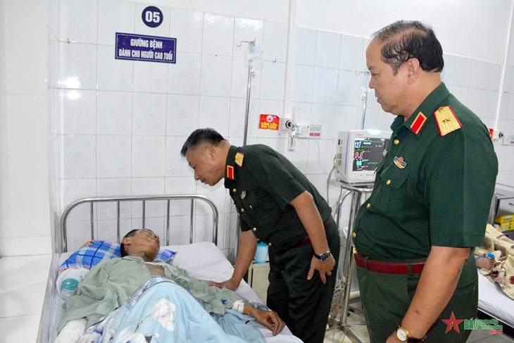 Trung tướng Lê Quang Minh động viên, thăm hỏi anh Nguyễn Hoàng là chồng của trung tá quân nhân chuyên nghiệp Nguyễn Thị Hường, Nhà máy Z176, Tổng cục Công nghiệp Quốc phòng (tử vong cùng con gái trong vụ cháy) - Ảnh: QĐND