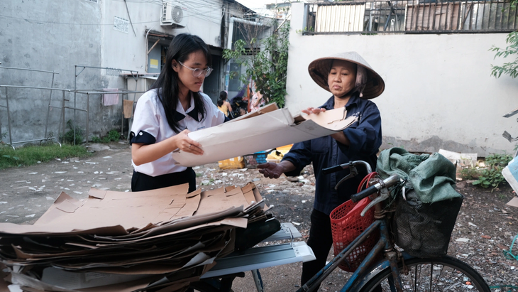 After school, Dinh Tran Giang My helps his mother rearrange the pile of garbage she has just collected - Photo: N.Phuong