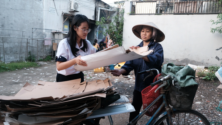 Sau giờ học, Đinh Trần Giáng My giúp mẹ sắp xếp lại đống ve chai vừa thu gom - Ảnh: N.PHƯỢNG