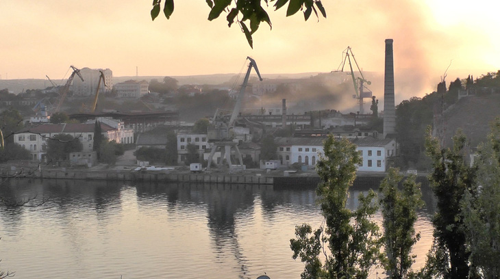 Khói bốc lên từ một xưởng đóng tàu được cho là đã bị Ukraine tấn công bằng tên lửa ở Sevastopol, bán đảo Crimea hôm 13-9 - Ảnh: REUTERS