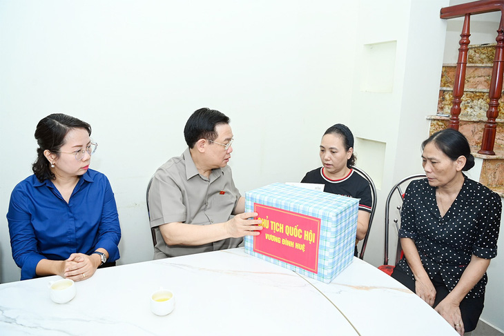 Chủ tịch Quốc hội Vương Đình Huệ thăm hỏi hộ dân sống liền kề chung cư mini đã giúp đỡ người dân thoát nạn khi vụ cháy xảy ra - Ảnh: LÂM HIỂN