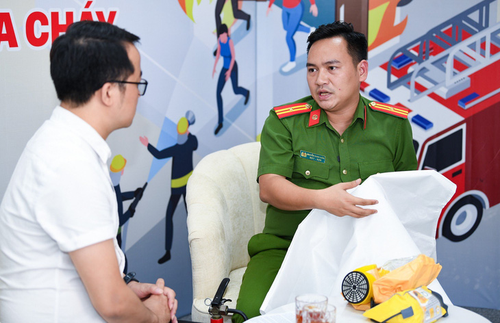 Thiếu tá Nguyễn Danh Luân giới thiệu và hướng dẫn một số vật dụng phòng cháy, chữa cháy, phòng độc - Ảnh: NAM TRẦN