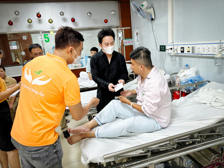 Ca sĩ Tùng Dương đến Bệnh viện Bạch Mai thăm hỏi, tặng quà nạn nhân vụ cháy chung cư mini đang điều trị tại đây sáng 15-9 - Ảnh: T.ĐIỂU