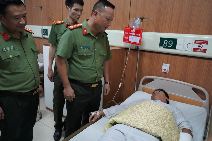 Đại tá Phạm Thanh Hùng thăm hỏi tình hình sức khỏe đại úy Hà Việt Anh - Ảnh: Công an cung cấp