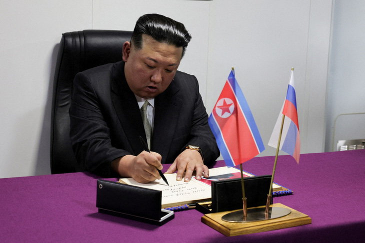 Sau khi xem hệ thống tên lửa và hệ thống pháo binh của tàu khu trục Marshal Shaposhnikov, ông Kim Jong Un viết lưu niệm trong cuốn sổ của các du khách danh dự - Ảnh: REUTERS
