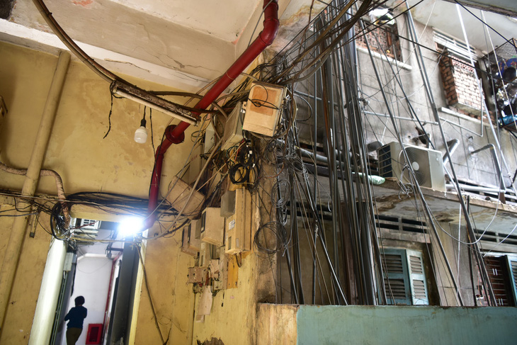 Hệ thống dây cáp, dây điện, ống nước chằng chịt bên trong một chung cư trên đường Nguyễn Trãi, quận 1, TP.HCM - Ảnh: T.T.D.