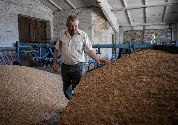 Nông dân địa phương tại kho chứa ngũ cốc gần tiền tuyến ở làng Velykomykhailivka, vùng Dnipropetrovsk, Ukraine ngày 15-8 - Ảnh: REUTERS