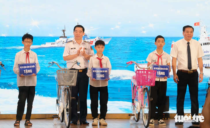 Trung tướng Bùi Quốc Oai - chính ủy Cảnh sát biển Việt Nam (thứ hai từ trái qua) - tặng xe đạp cho các em học sinh - Ảnh: HÀ THANH