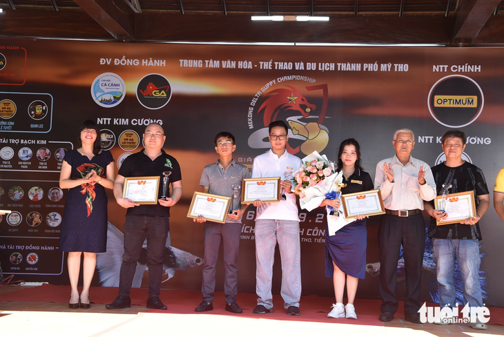 Ông Lê Ngọc Tú - chủ tịch Hiệp hội cá bảy màu Việt Nam (thứ 2 từ phải sang) - trao bằng khen cùng kỷ niệm chương cho các đơn vị tham gia - Ảnh: HOÀI THƯƠNG