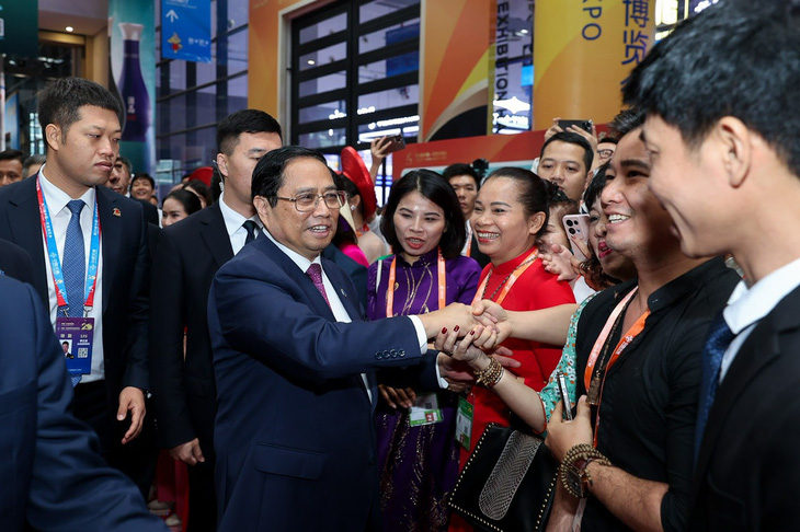 Thủ tướng Phạm Minh Chính bắt tay với các đại diện doanh nghiệp Việt Nam tham gia hội chợ - Ảnh: NHẬT BẮC