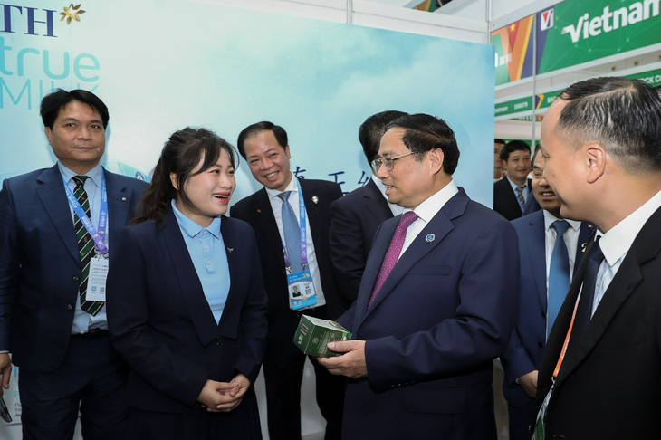 Thủ tướng Phạm Minh Chính hỏi một đại diện doanh nghiệp tham gia hội chợ về tiềm năng kinh doanh tại Trung Quốc - Ảnh: NHẬT BẮC