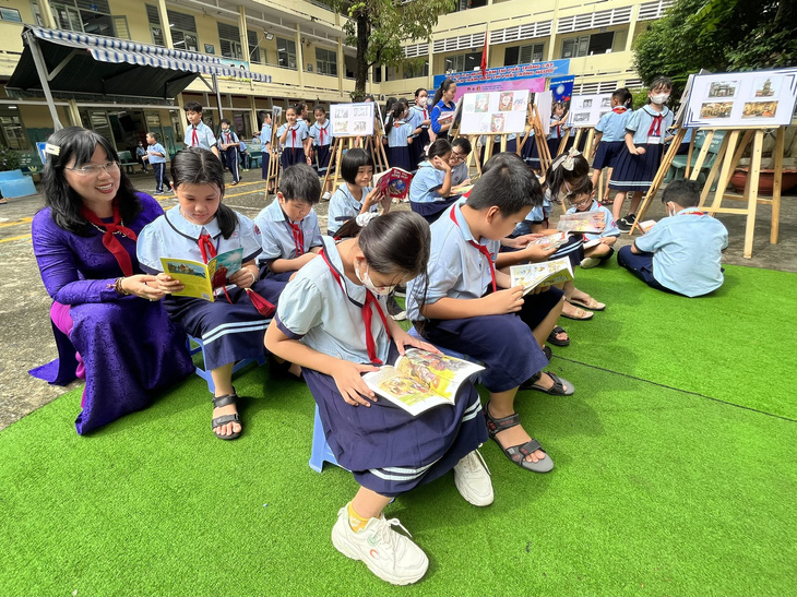 Các em học sinh Trường tiểu học Phú Thọ ngồi đọc sách tại Góc lịch sử - địa lý ngày 18-9 - Ảnh: MỸ DUNG