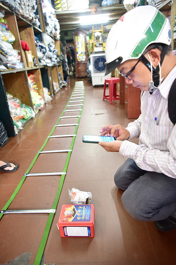 Người dân ở chung cư tìm mua thang dây, mặt nạ phòng khói (giá 180.000 đồng) tại cửa hàng bán thiết bị bảo hộ trên đường Nguyễn Công Trứ, quận 1, TP.HCM - Ảnh: T.T.D.
