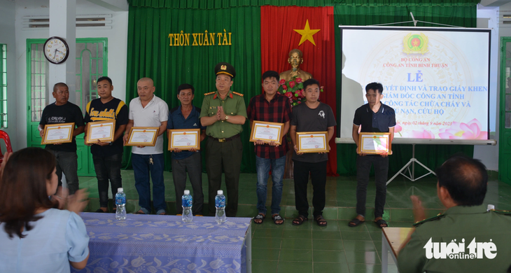 Đại tá Trần Văn Mười - phó giám đốc Công an tỉnh Bình Thuận - trao tặng giấy khen của giám đốc công an tỉnh đến những người dân cùng tham gia hỗ trợ trong vụ cháy - Ảnh: ĐỨC TRONG