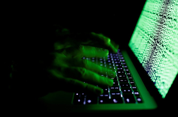Một người dùng gõ bàn phím máy tính trước mã mạng - Ảnh: REUTERS