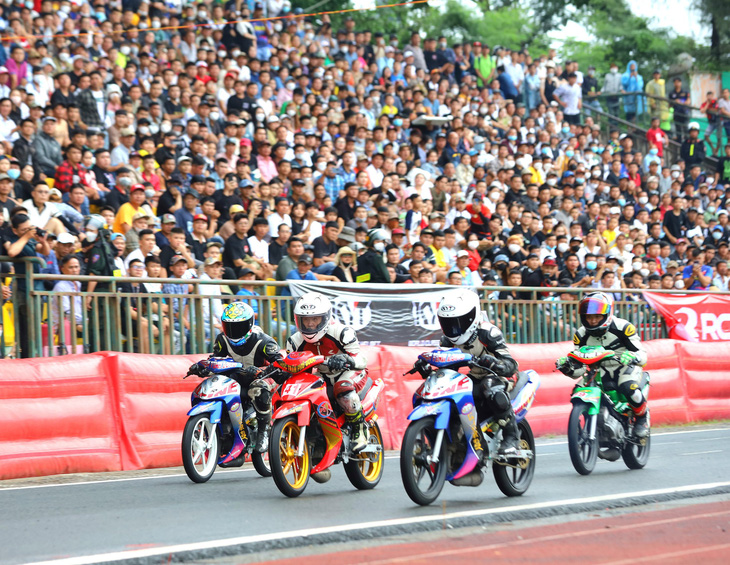 Khán giả đội mưa xem đua xe mô tô tại Cần Thơ - Ảnh: T.LŨY