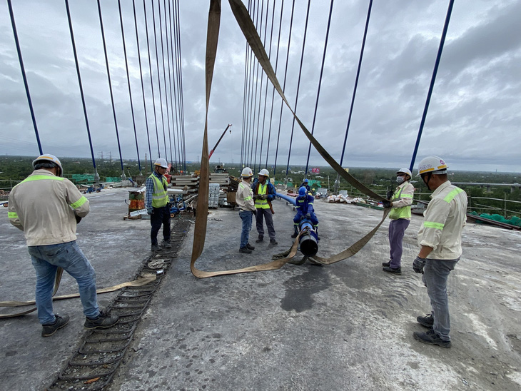 Công nhân đang chuẩn bị căng dây cáp trên cầu Mỹ Thuận 2 trong sáng 2-9 - Ảnh: MẬU TRƯỜNG