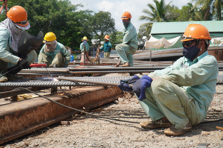 Tại dự án cầu Rạch Miễu 2, công nhân thi công cốt thép trên bờ vẫn làm việc trong những ngày lễ - Ảnh: MẬU TRƯỜNG