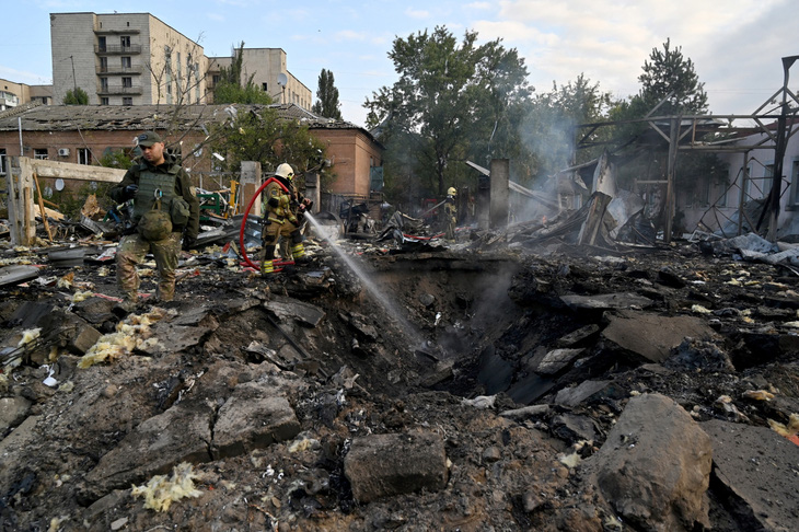 Lực lượng cứu hỏa Ukraine tìm kiếm mảnh vỡ tên lửa rơi xuống một khu vực công nghiệp tại thủ đô Kiev trong cuộc tấn công hồi cuối tháng 9 - Ảnh: AFP
