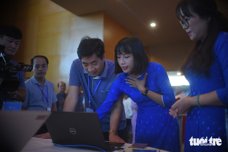 Người dân Quy Nhơn thích thú lắng nghe nhân viên các đơn vị tham gia triển lãm giới thiệu về các ứng dụng công nghệ mới - Ảnh: LÂM THIÊN