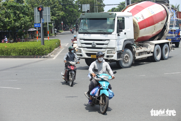 Nhiều xe máy từ đường Nguyễn Văn Linh đi thẳng vào đường dẫn cao tốc hoặc rẽ trái về các tỉnh miền Tây vẫn bất chấp vượt đèn đỏ, không chấp hành đèn tín hiệu giao thông khi các xe lớn đang rẽ phải - Ảnh: MINH HÒA