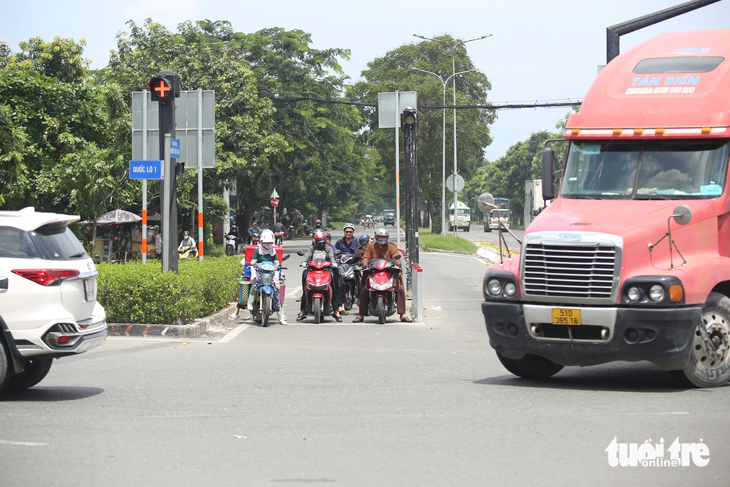 Lúc trước chưa có đèn đỏ, xe máy đi thẳng sẽ xung đột hướng với xe lớn đang rẽ phải từ đường Nguyễn Văn Linh vào quốc lộ 1, dễ va chạm giao thông khi xe máy lọt vào “điểm mù” xe lớn - Ảnh: MINH HÒA