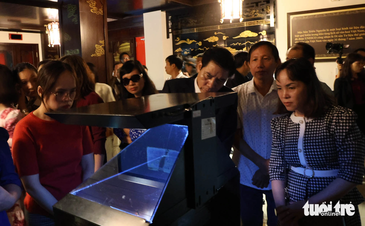 Người tham dự trải nghiệm không gian Mộc bản triều Nguyễn thông qua ứng dụng Hologram - Ảnh: M.V