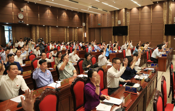 Các đại biểu giơ tay biểu quyết thông qua nghị quyết - Ảnh: HĐND TP Hà Nội