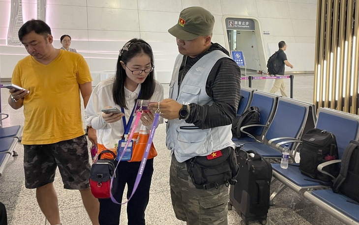 Tình nguyện viên hướng dẫn phóng viên Việt Nam tại ga Đông Hàng Châu - Ảnh: ĐỨC KHUÊ