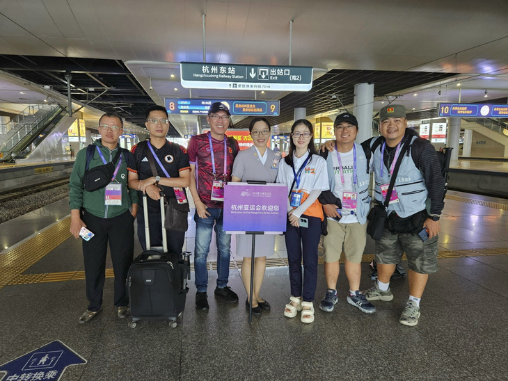 Nhóm phóng viên Việt Nam chụp ảnh cùng các tình nguyện viên, nhân viên tại ga tàu lửa Đông Hàng Châu - Ảnh: CTV