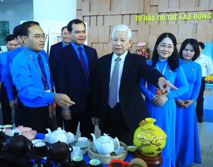 Nguyên chủ tịch nước Nguyễn Minh Triết và chủ tịch Tổng liên đoàn lao động Việt Nam Nguyễn Đình Khang xem trưng bày các sản phẩm tiêu biểu của người lao động - Ảnh: T.D.