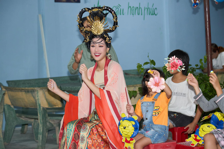 Hoa hậu Khánh Vân luôn tươi cười mặc dù chiếc mũ đội đầu khá nặng