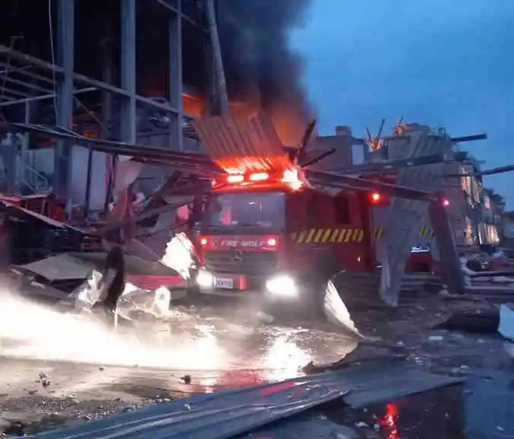 Một vụ nổ đã xảy ra trong lúc lính cứu hỏa khống chế đám cháy tại nhà máy ở Đài Loan ngày 22-9. Bức ảnh cho thấy một xe cứu hỏa bị các tấm tôn rơi đè lên sau vụ nổ - Ảnh: TAIWAN NEWS/PCFD
