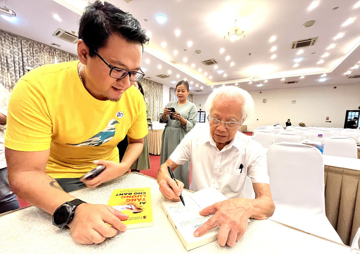 Giáo sư Hồ Ngọc Đại ký tặng sách cho người hâm mộ tại lễ ra mắt sách - Ảnh: MỸ DUNG